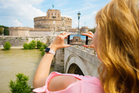 Woman taking photo of famous Castel SantâAngelo in Rome, Italyの写真素材