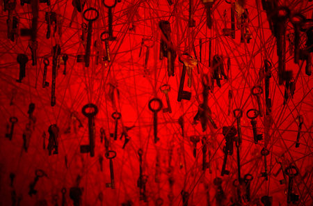 Many old keys on red backgroundの写真素材
