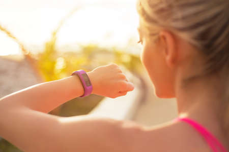 Fit girl using wearable tech during morning workoutの写真素材