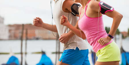 Man and woman running together in cityの写真素材
