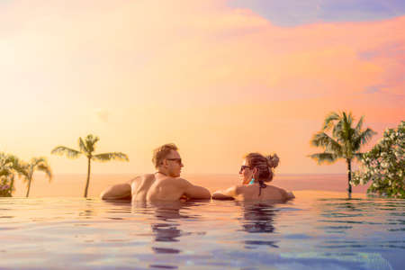 Happy couple on honeymoon in luxury hotel poolの写真素材