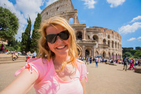 Tourist woman taking selfie in front of Colosseum in Romeの写真素材