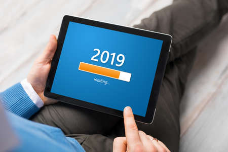 Conceptual image of man looking at tablet and getting ready for New Year.の写真素材