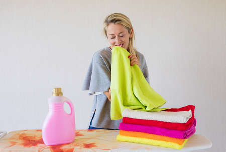 Woman feeling happy about soft fresh laundryの写真素材