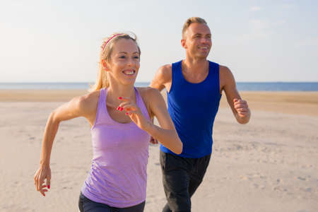 Happy people running outdoors togetherの写真素材