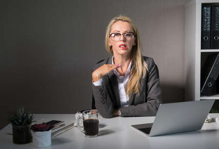 Frustrated woman working late at officeの写真素材