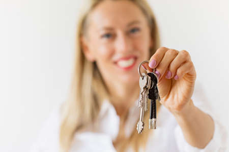 Woman holding new house or apartment keysの写真素材