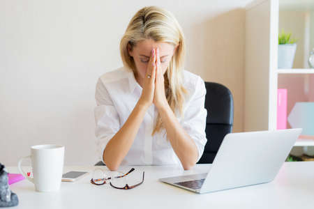 Woman thinking about work problems in officeの写真素材