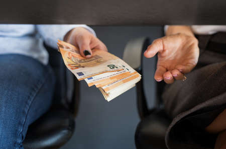 Two persons giving and taking a bribe moneyの写真素材