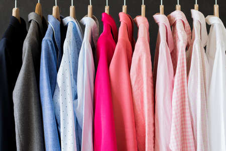 Different colored shirts hanging in rowの写真素材