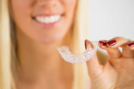 Woman holding teeth whitening trayの写真素材