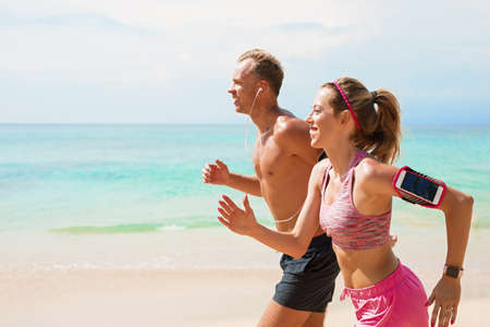 Man and woman running on beach togetherの写真素材