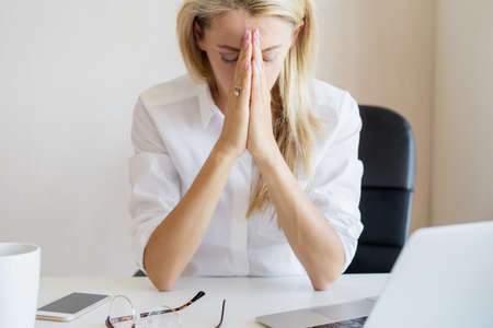 Woman thinking about something at work in officeの写真素材