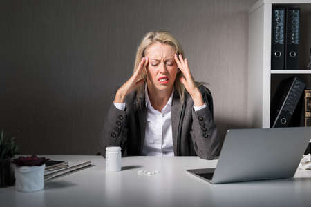 Woman feeling headache at workの写真素材