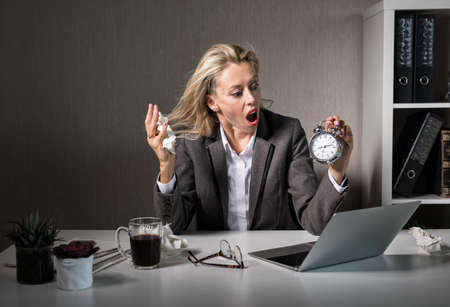 Woman at office in stress about deadlineの写真素材