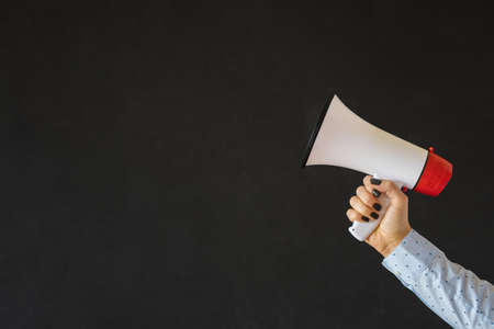 Person holding megaphone on empty black backgroundの写真素材