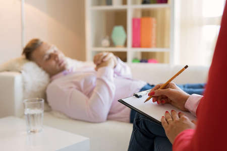 Man lying in couch during hypnotherapyの写真素材