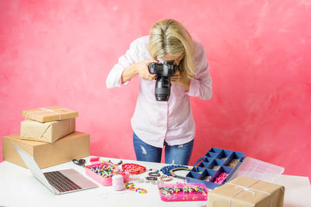 Woman taking photos of her own created products for putting them on sale onlineの写真素材