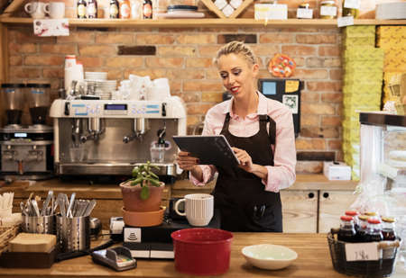 Woman using tablet computer in cafeの写真素材