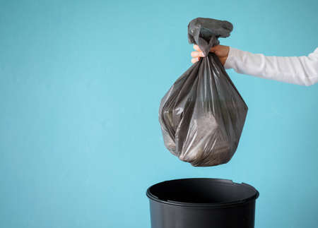 Hand holding garbage in plastic bagの写真素材