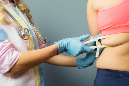 Dietician doctor using body fat caliperの写真素材