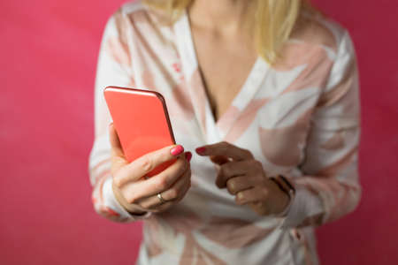 Woman holding mobile phone in handsの写真素材