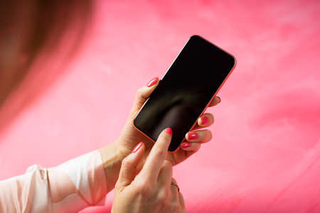 Woman using mobile phone and touching screen with fingerの写真素材