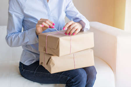 Woman unpacking delivery boxes with merchandise from online ordersの写真素材