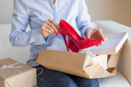 Woman unpacking new shoes delivered by postの写真素材