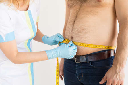 Doctor measuring man's body fatの写真素材