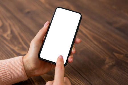 Woman using mobile phone. Smartphone mockup with empty white screen.の写真素材