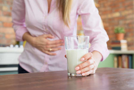 Woman feeling sick by drinking milkの写真素材