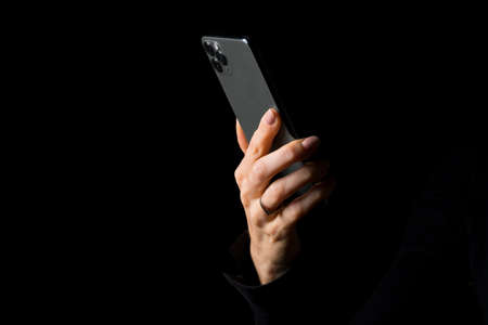 Person holding smartphone, photo isolated on black backgroundの写真素材