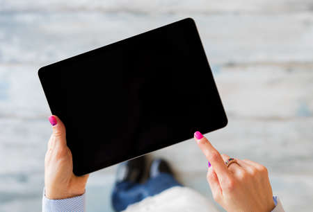 Person holding tablet in hands, view from aboveの写真素材