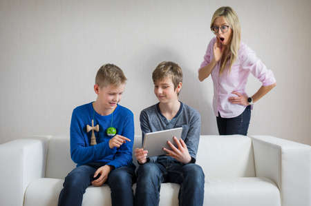 Mother in shock of what her sons are doing on their tabletの写真素材
