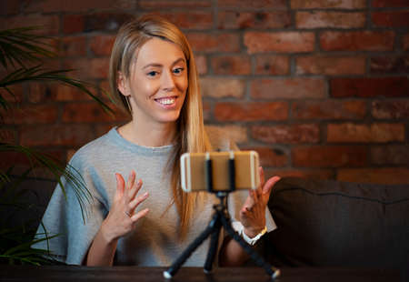 Woman recording video blog at homeの写真素材