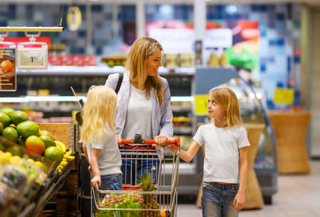 Mother and daughter shopping for groceries in supermarketの写真素材