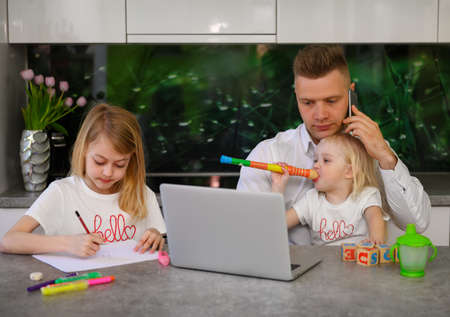 Father of two daughters trying to work from homeの写真素材