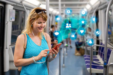 Concept photo of woman using different apps and services on mobile phone while riding in public transportの写真素材