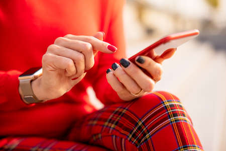 Close-up photo of woman holding mobile phone in handsの写真素材