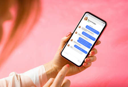 Woman using messaging app on mobile phone. Mockup of sample chat application interface.の写真素材