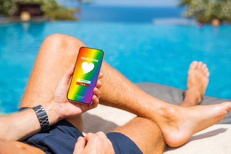 Man using gay and LGBT dating app on his mobile phoneの写真素材
