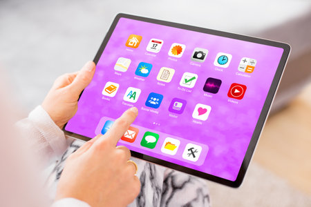 Woman holding in hands and using tablet computerの写真素材
