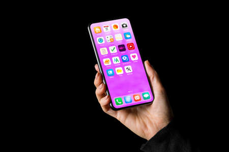 Person holding in hand mobile phone with app icons on home screenの写真素材
