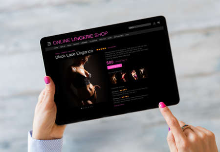 Woman browsing online lingerie store on her tabletの写真素材