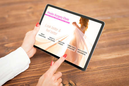 Woman looking at plastic surgery clinic's websiteの写真素材