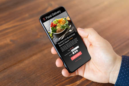 Man ordering food online on mobile phoneの写真素材