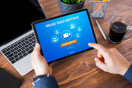 Man using online video meeting app on tablet computerの写真素材