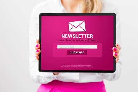 Woman showing tablet with newsletter signup pageの写真素材