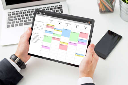 Businessman using calendar app on tablet computerの写真素材